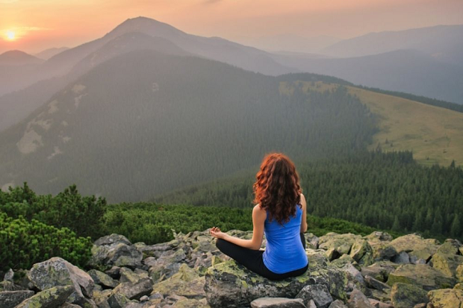 Featured image of top 30 yoga retreats for November 2017 with female yogi overlooking Transylvanian sunset in the mountains with orange, pink and yellow colors as the sun is coming down at the 6-Day Detox, Wellness and Yoga Retreat in Romania 